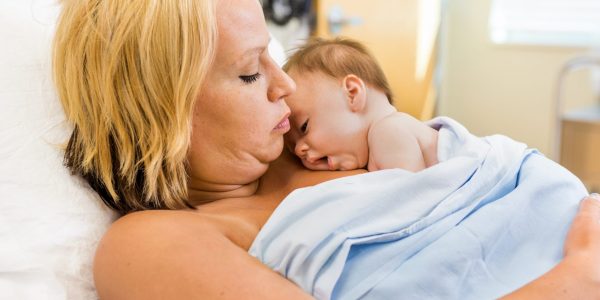 Loving new mother practising skin-to-skin time with newborn baby